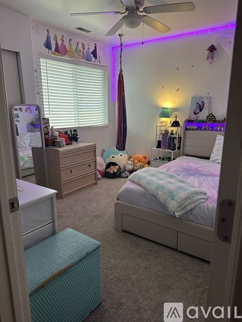 A bedroom with a bed, dresser, and a ceiling fan.