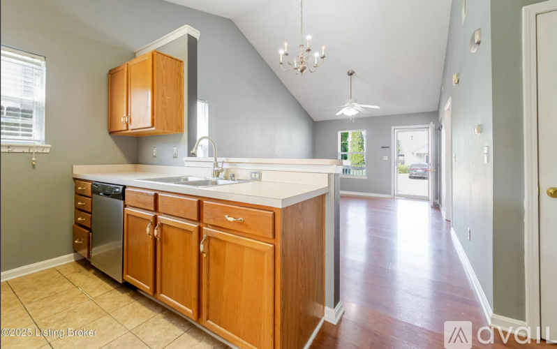 A kitchen with wooden cabinets and a white sink.