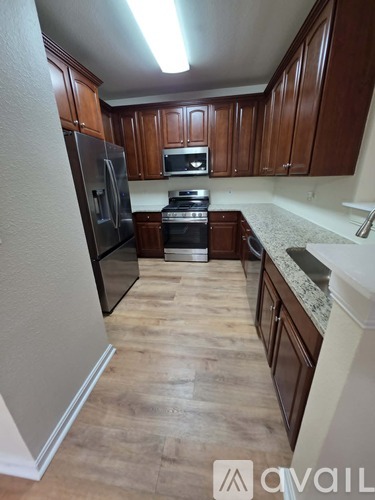 A kitchen with wooden cabinets and a refrigerator.