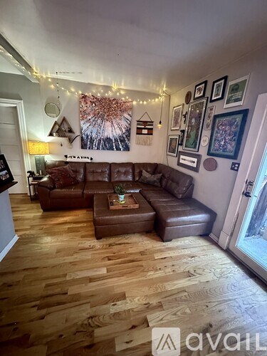 A living room with a brown leather couch and a coffee table.