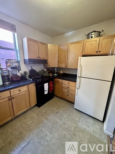 A kitchen with wooden cabinets and a white refrigerator.