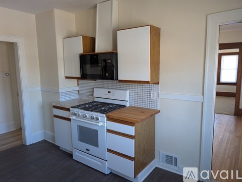A kitchen with a white oven and microwave above a counter.