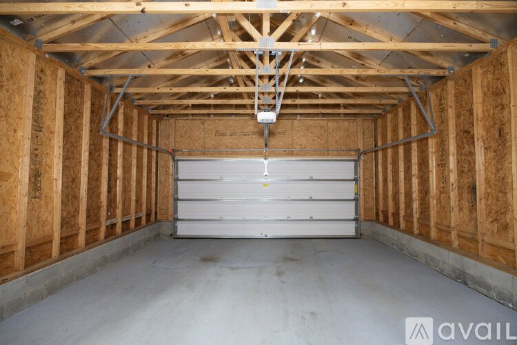 A spacious garage with a white door and wooden walls.