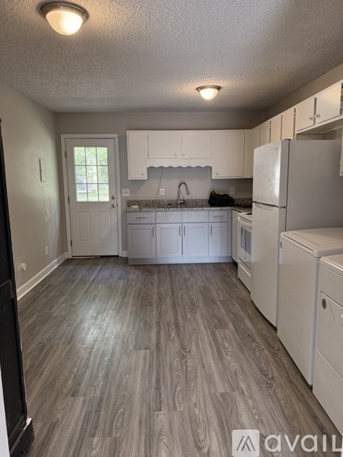 A kitchen with white cabinets and a refrigerator.