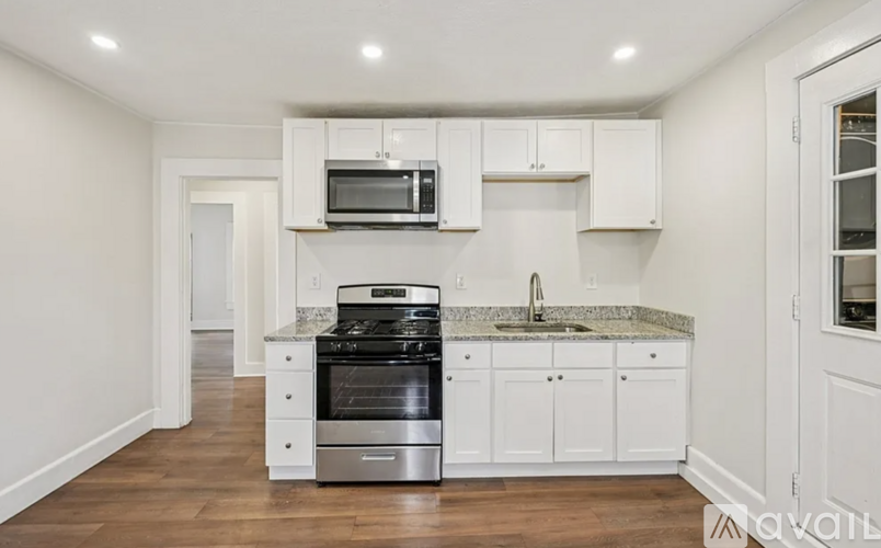 A kitchen with white cabinets and a granite countertop.