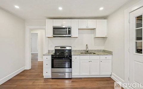 A kitchen with white cabinets and a granite countertop.