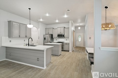 A modern kitchen with a large island and stainless steel appliances.