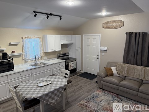 A kitchen with a table and chairs in front of it.