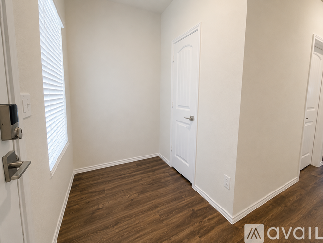 A room with wooden flooring and white walls.