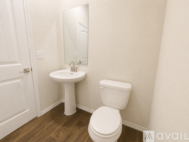 A white toilet sits next to a white sink in a small bathroom.