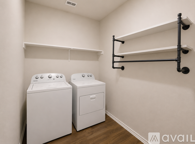 Two white front loading washing machines in a laundry room.