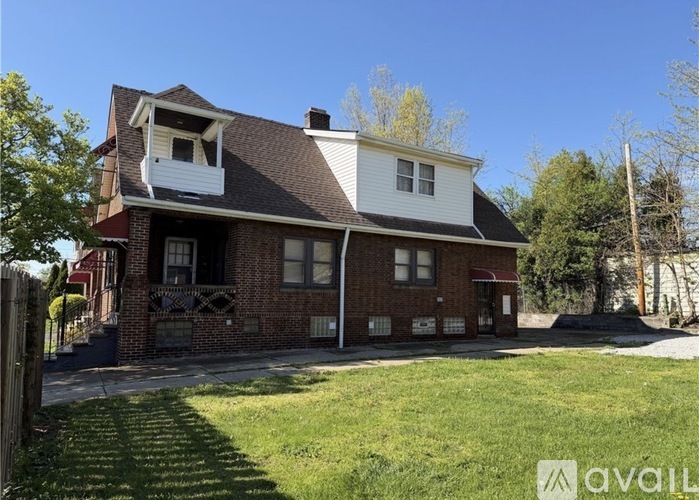 A house with a red brick exterior and a white trim is for sale.
