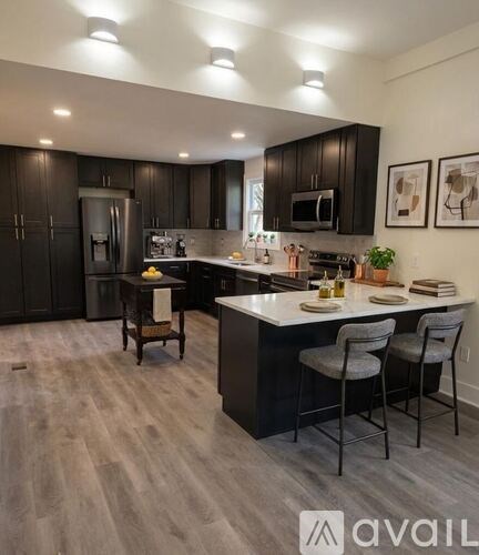 A modern kitchen with dark wood cabinets and a white island.