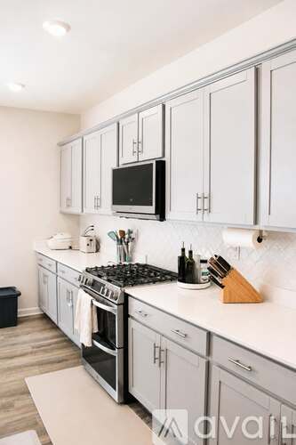 A kitchen with white cabinets and a black stove top.