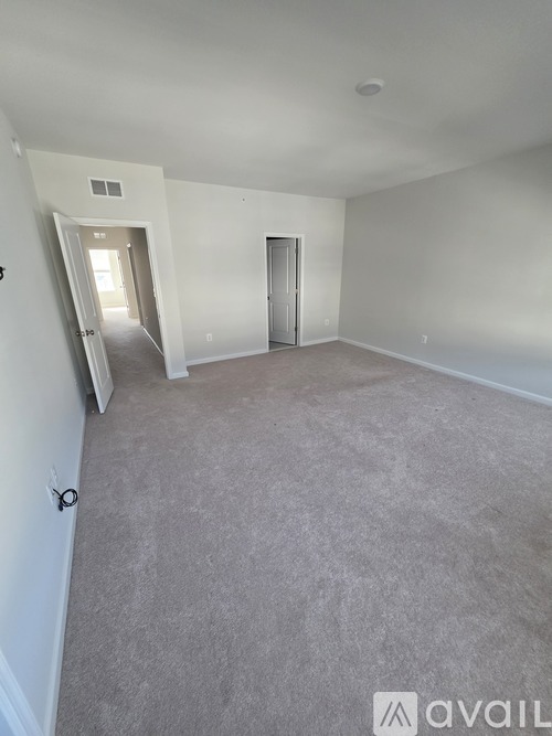 A spacious room with carpeted floor and two doors.