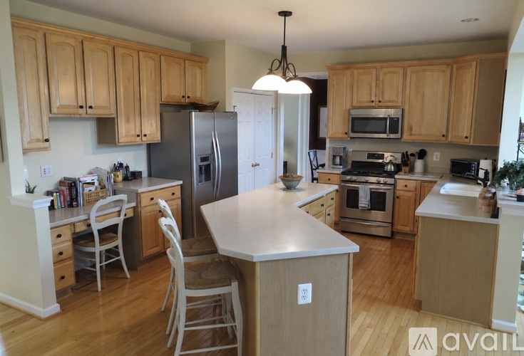 A kitchen with wooden cabinets and a large island in the middle.