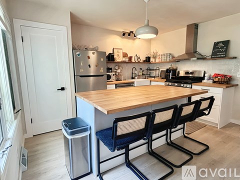 A kitchen with a wooden table and black chairs.