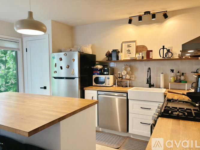 A kitchen with a wooden counter top and stainless steel appliances.