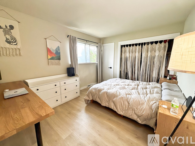 A bedroom with a bed, dresser, and a painting of a zebra on the wall.