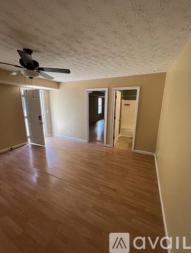 A room with a ceiling fan and wooden flooring.