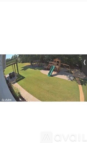 A playground with a green slide and a wooden structure.