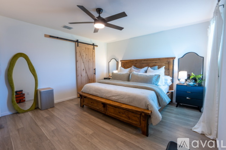 A bedroom with a bed, nightstand, and a ceiling fan.