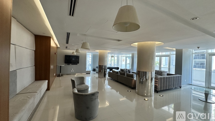 A spacious living room with a white floor and a large window.