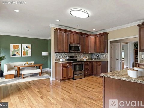 A kitchen with wooden cabinets and a green wall.