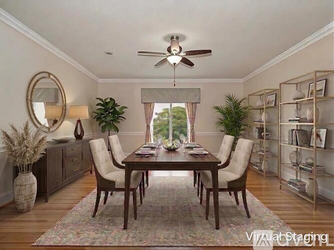 A dining room with a table set for four and a ceiling fan.