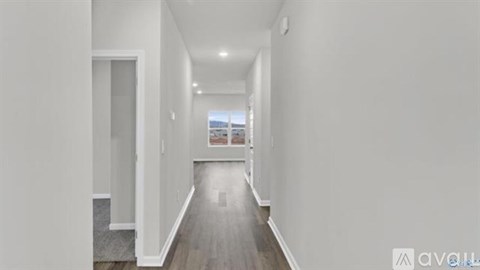A long, narrow hallway with a view of the city through the window.