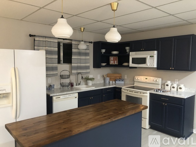 A kitchen with a white fridge and black cabinets.