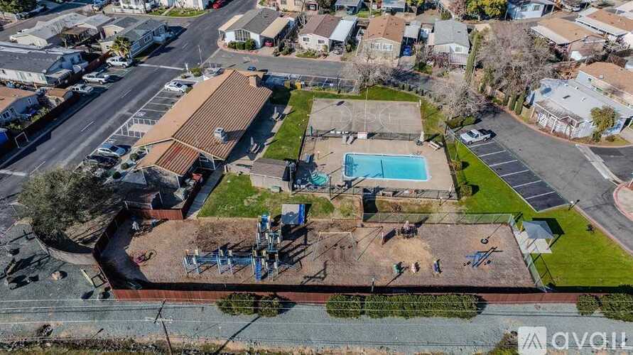 An aerial view of a residential area with a swimming pool and a playground.
