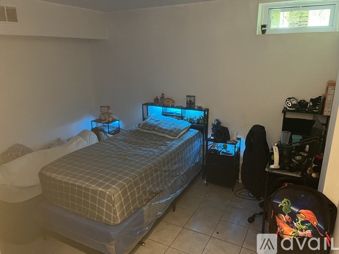 A bedroom with a bed, desk, and chair.