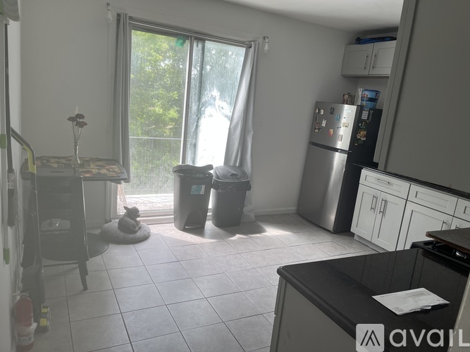A kitchen with a black counter and white cabinets.