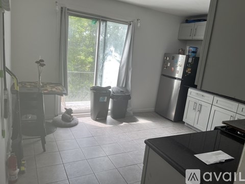 A kitchen with a black counter and white cabinets.