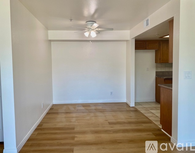 A spacious room with wooden flooring and a ceiling fan.
