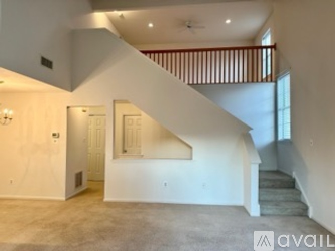 A spacious room with a staircase leading to the upper floor.