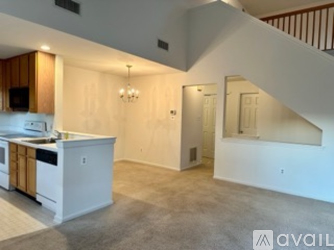 A kitchen with white cabinets and a countertop is available for rent.