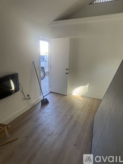 A room with a wooden floor and a television on the wall.