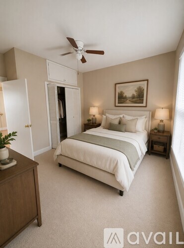 A bedroom with a bed, nightstand, and a ceiling fan.