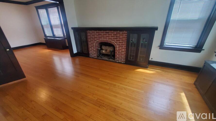 A room with a fireplace and wooden floors.