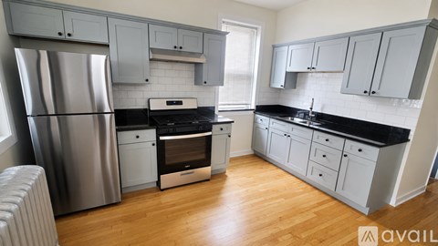 A kitchen with a refrigerator, oven, and cabinets.