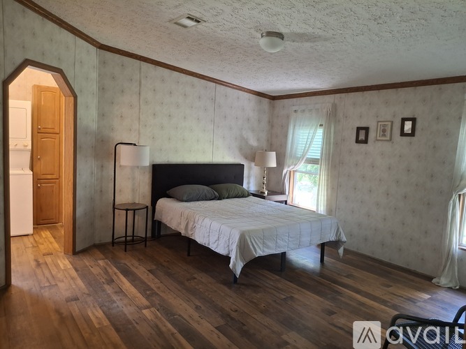 A bedroom with a bed, nightstand, and lamp.