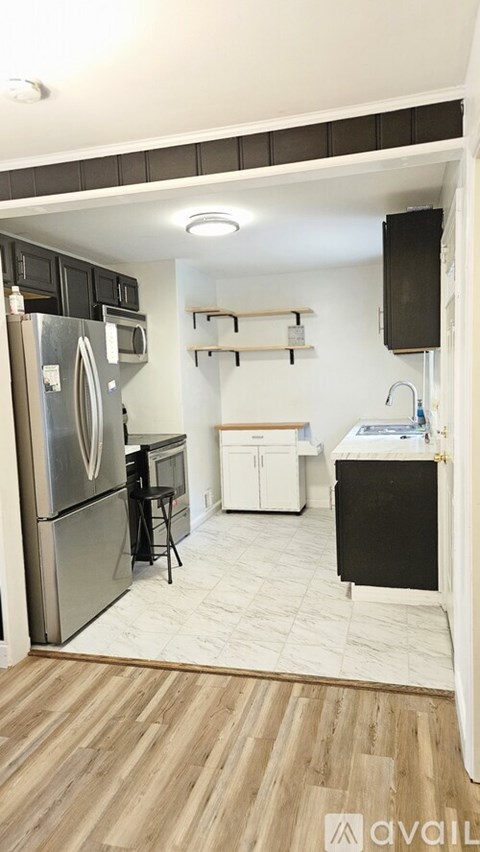 A kitchen with a refrigerator, microwave, and oven.