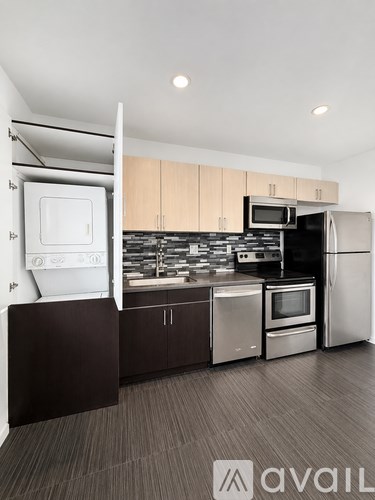 A modern kitchen with wooden cabinets and stainless steel appliances.