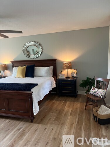A bedroom with a bed, nightstand, and chair.
