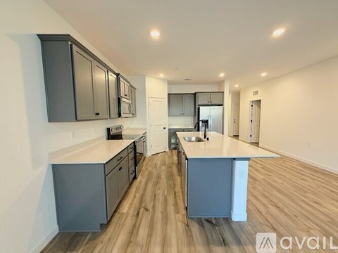 A kitchen with dark wood cabinets and light wood flooring.