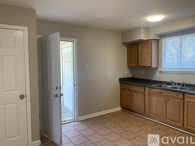 A kitchen with wooden cabinets and a tiled floor.