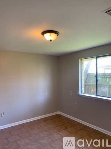 A room with a window and a tiled floor.