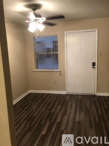 A room with a ceiling fan and a door.